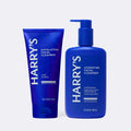 Two blue bottles of Harry's facial cleanser on a white background