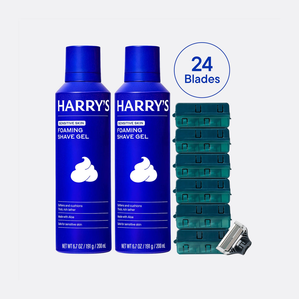 Two bottles of Harry's foaming shave gel with a stack of razor heads and a razor on a white background.