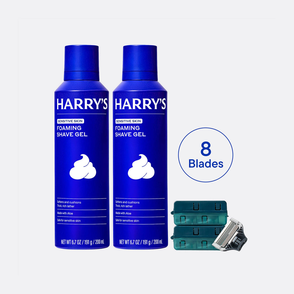 Two bottles of Harry's foaming shave gel with a set of razor heads on a white background