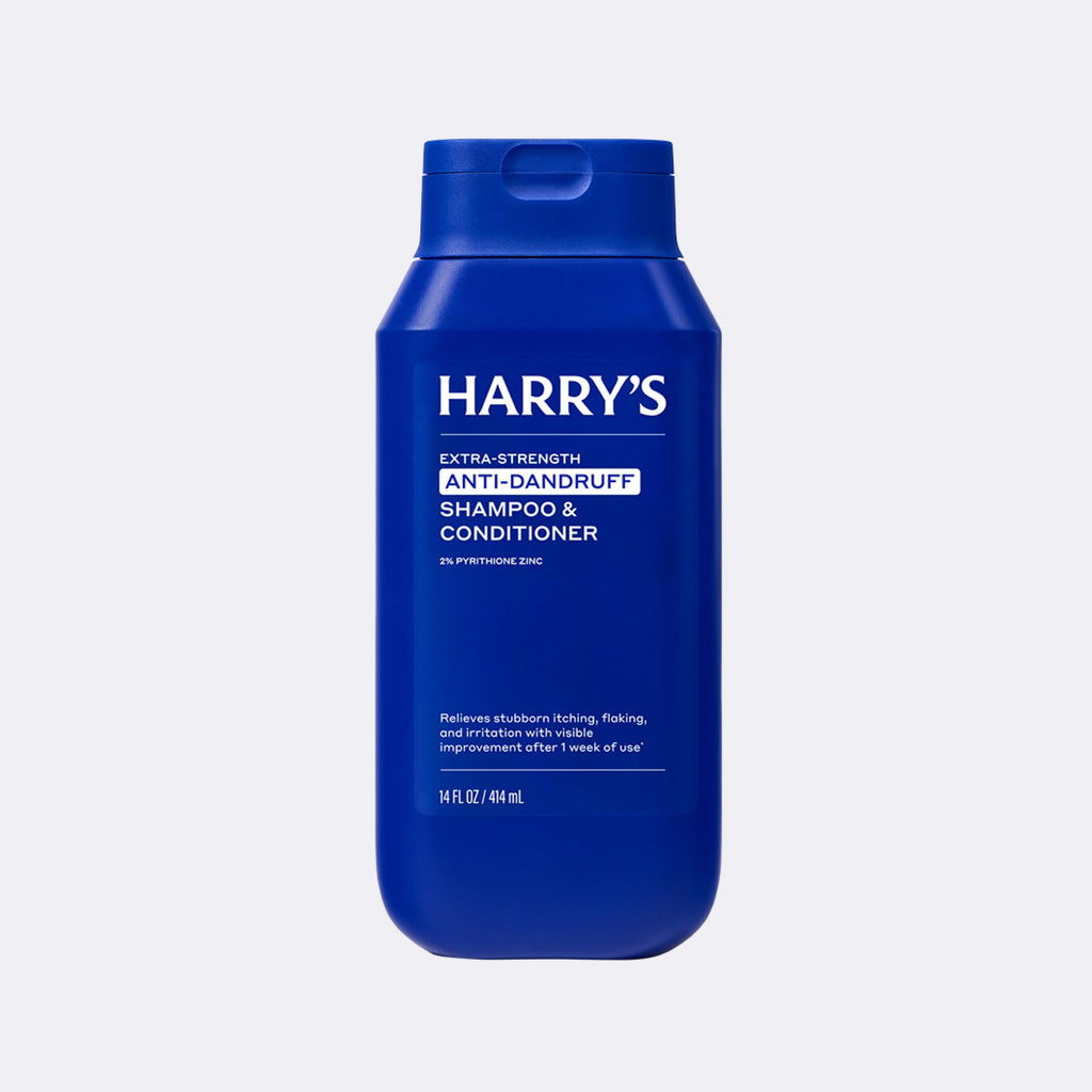 Blue bottle of Harry's shampoo and conditioner on a light gray background