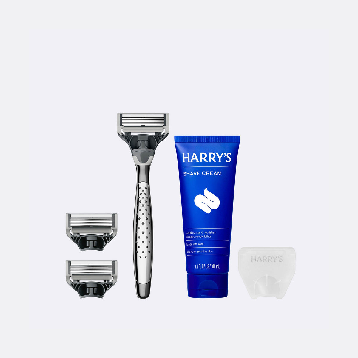 Harry's shaving kit with razor, razor heads, and shave cream on a white background