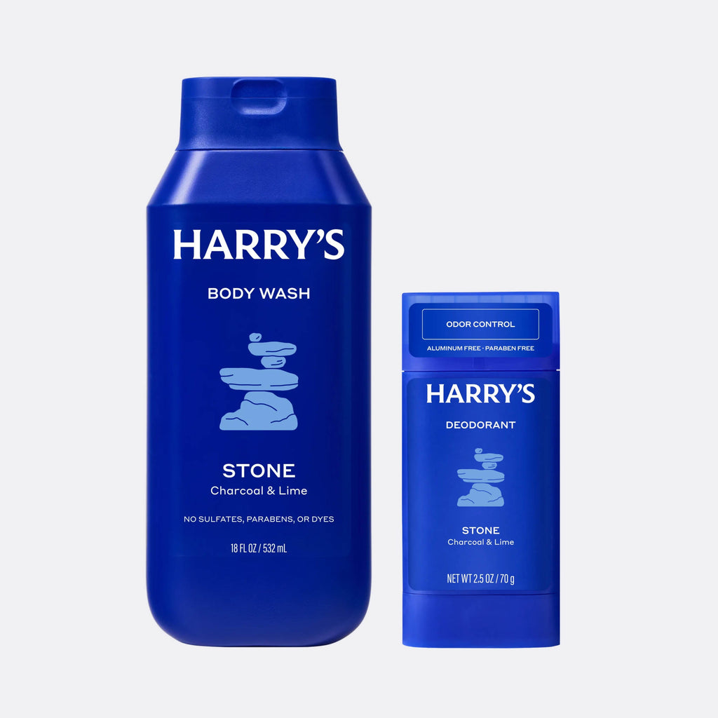 Blue bottles of Harry's body wash and deodorant on a light gray background
