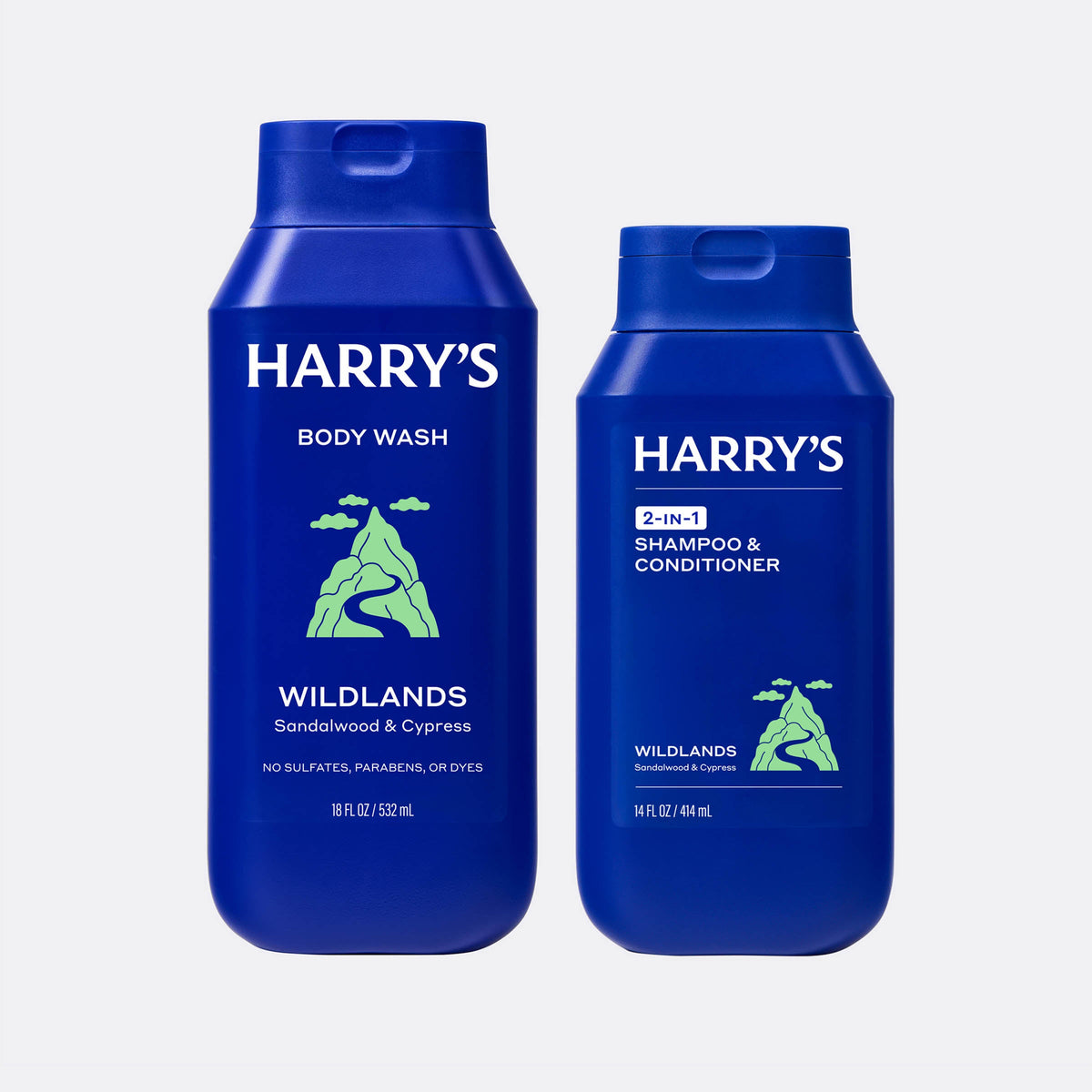 Two blue bottles of Harry's Wildlands body wash and shampoo & conditioner on a white background