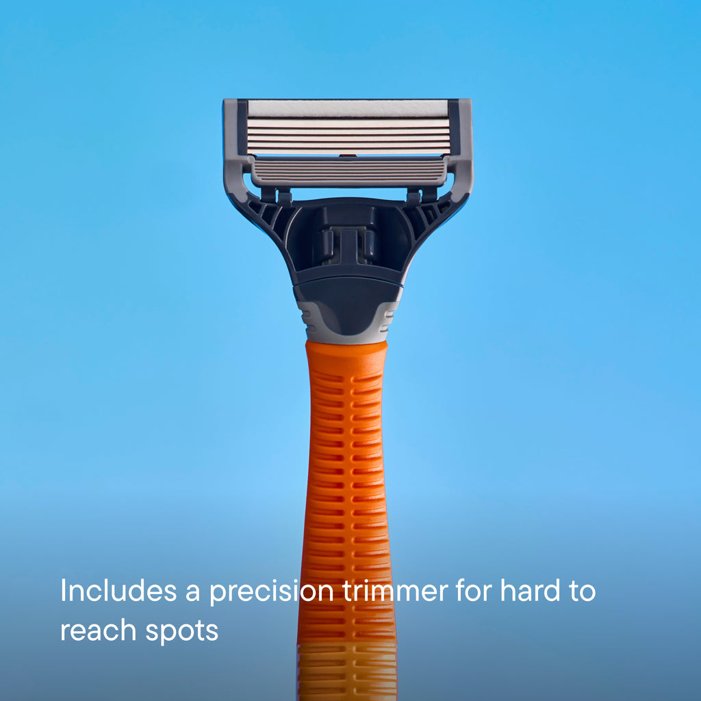 A close-up of a multi-shaver head with an orange and gray handle, shown against a blue gradient background with the text 'Includes a precision trimmer for hard to reach spots'.