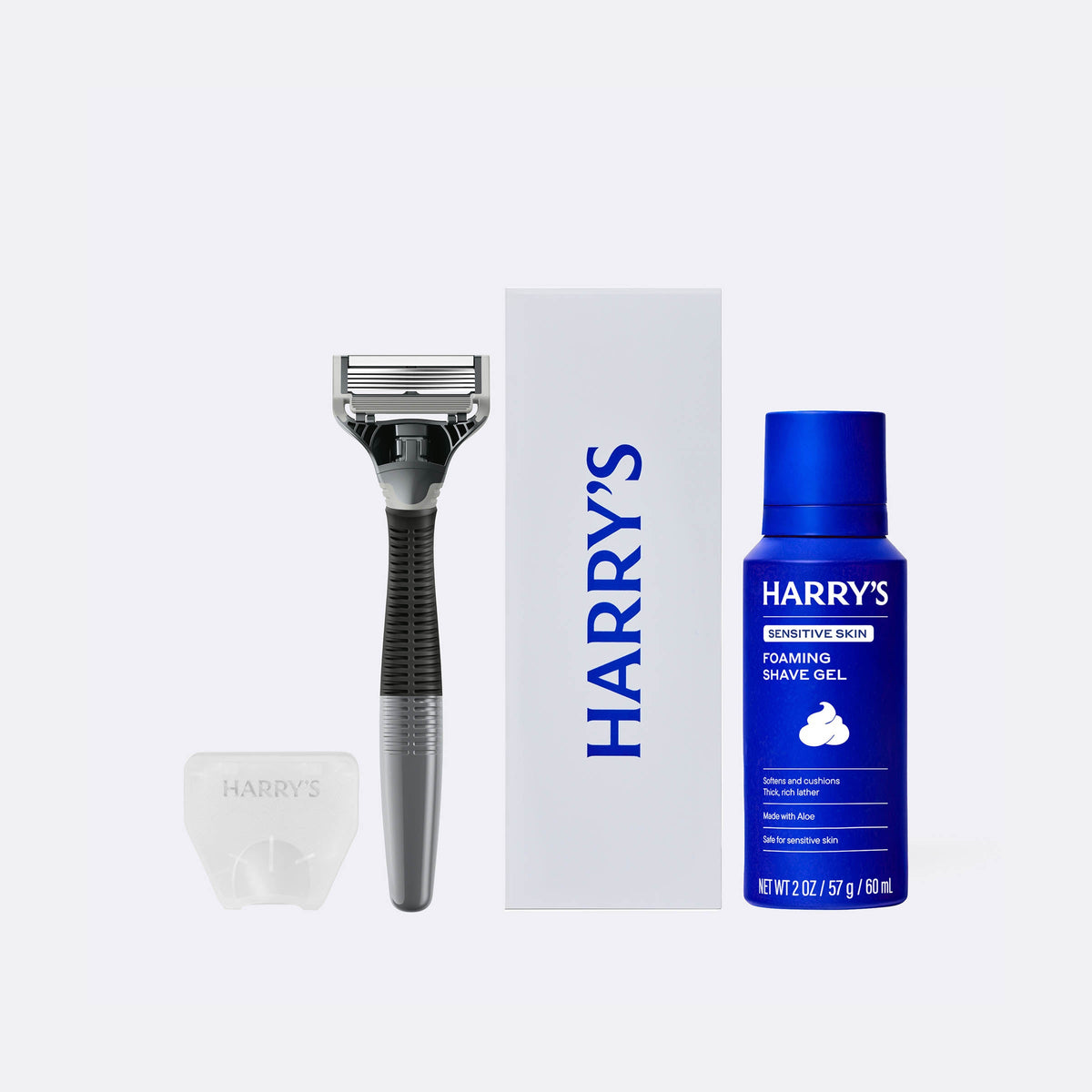 Harry's shaving kit with razor, shaving gel, and brush on a white background