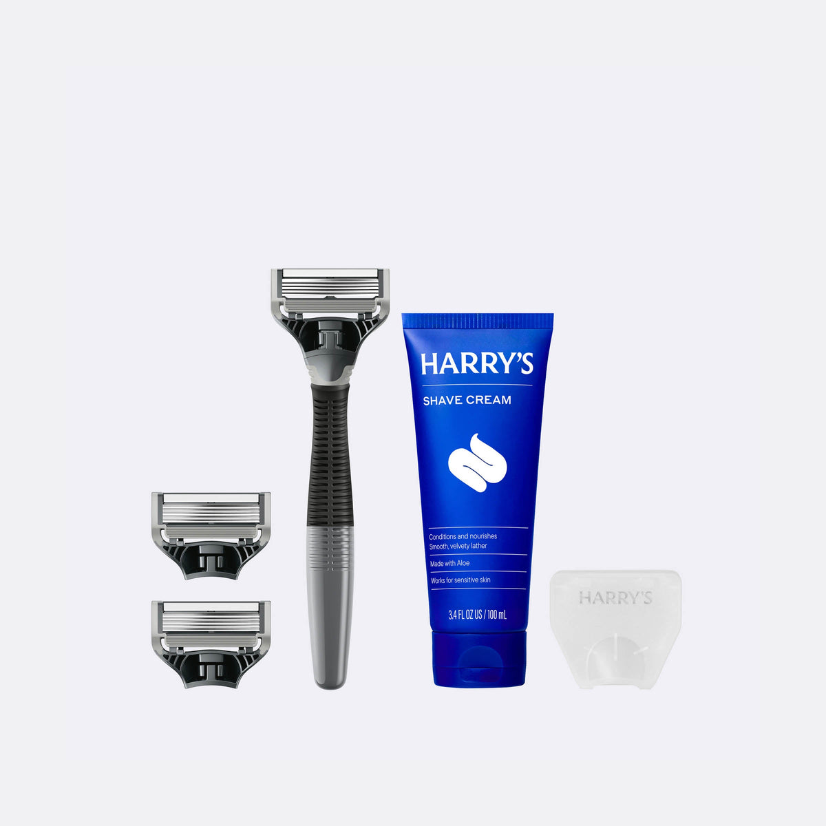 Harry's shaving kit with razor, razor heads, and shave cream on a white background