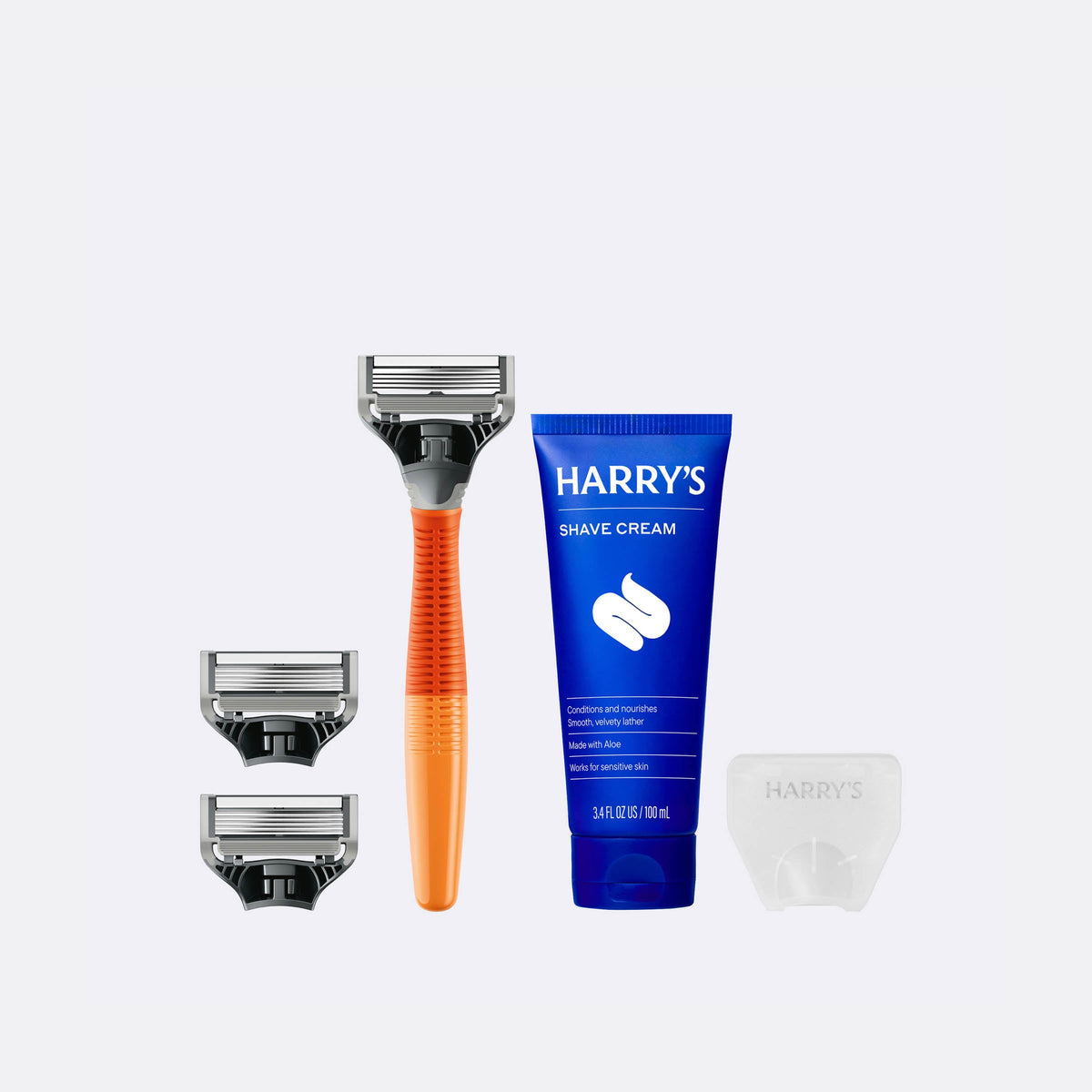 Harry's shaving kit with razor, razor heads, and shave cream on a white background