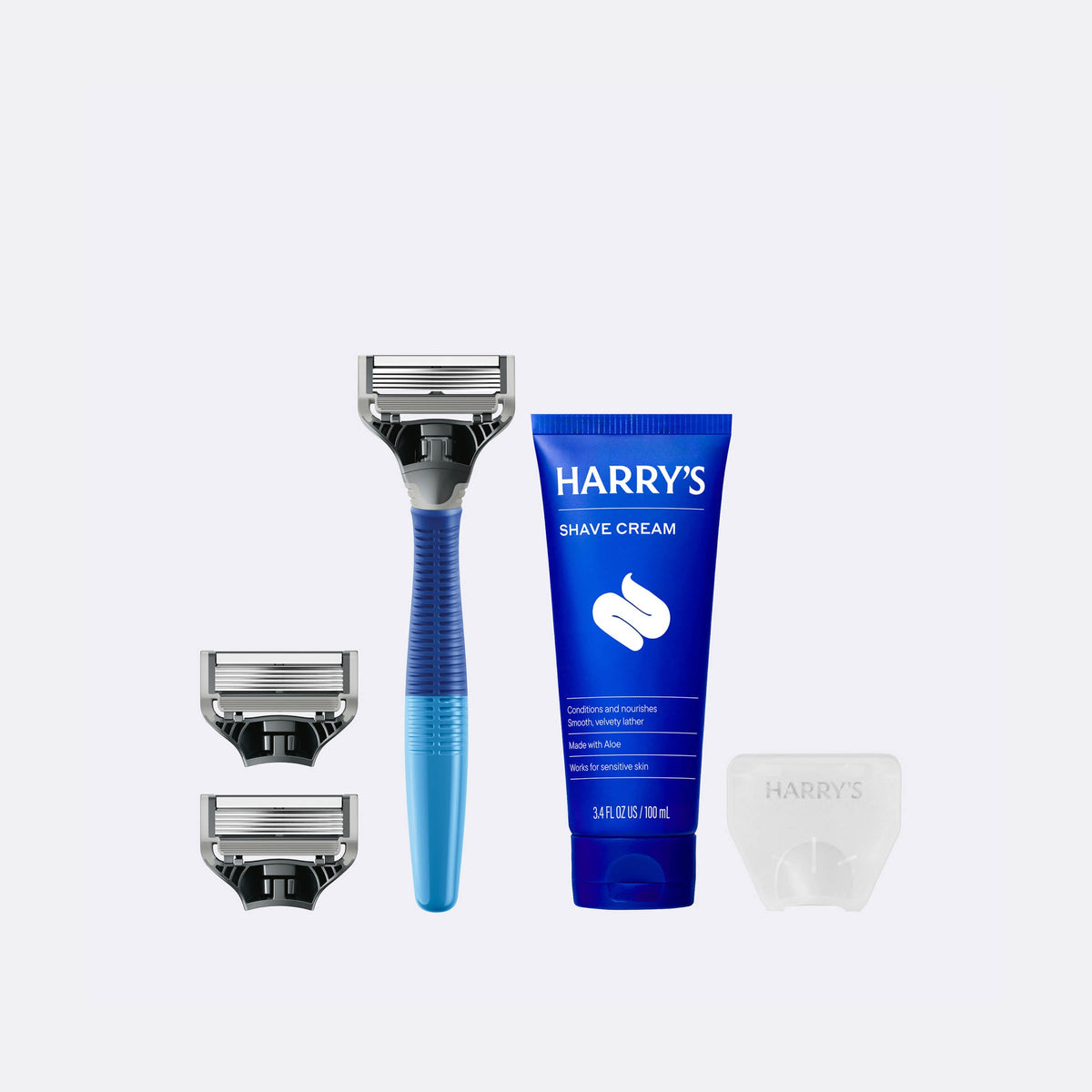 Harry's shaving kit with razor, razor heads, and shave cream on a white background