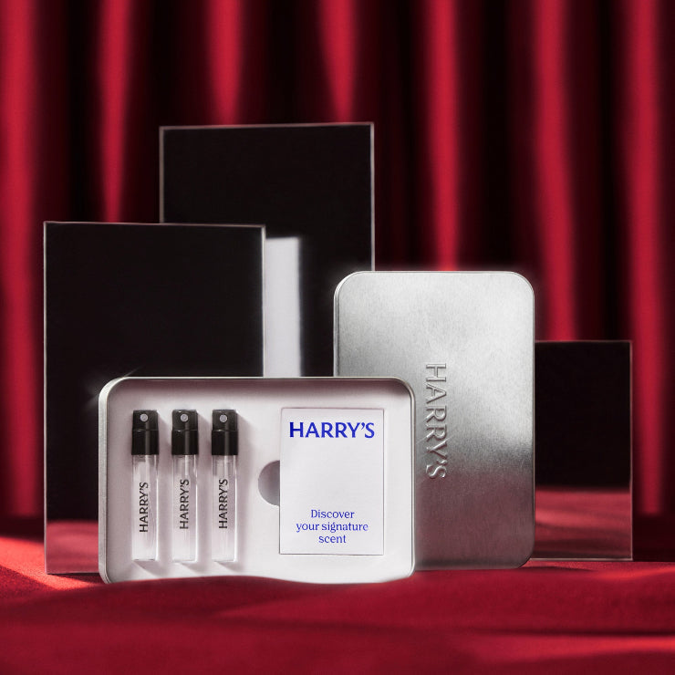 Harry's sample set with three small bottles and a display case on a red background