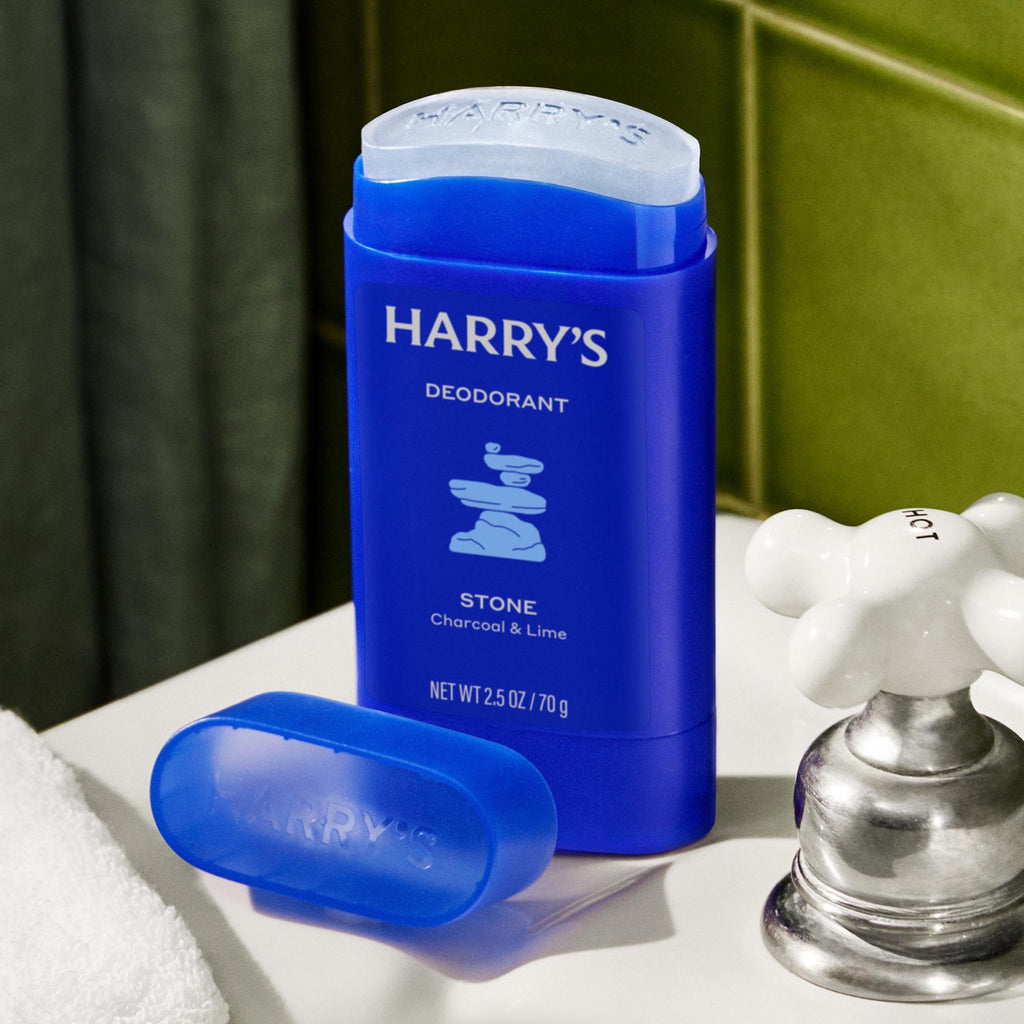 Blue deodorant stick with 'Harry's' branding on a bathroom counter.