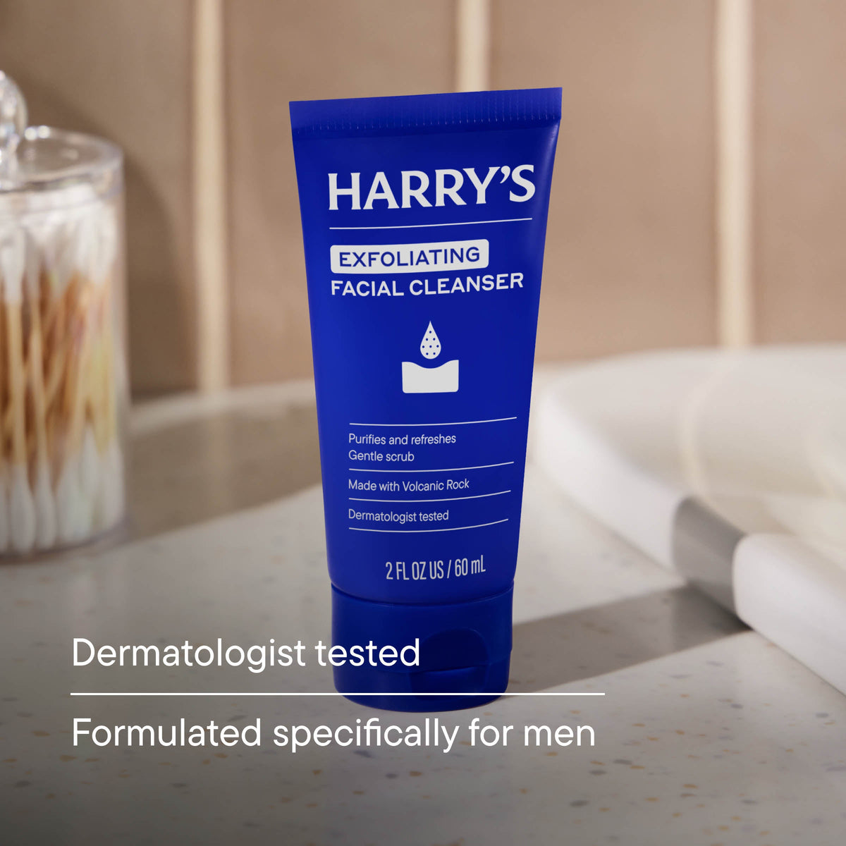 Blue tube of Harry's Exfoliating Facial Cleanser on a bathroom counter.