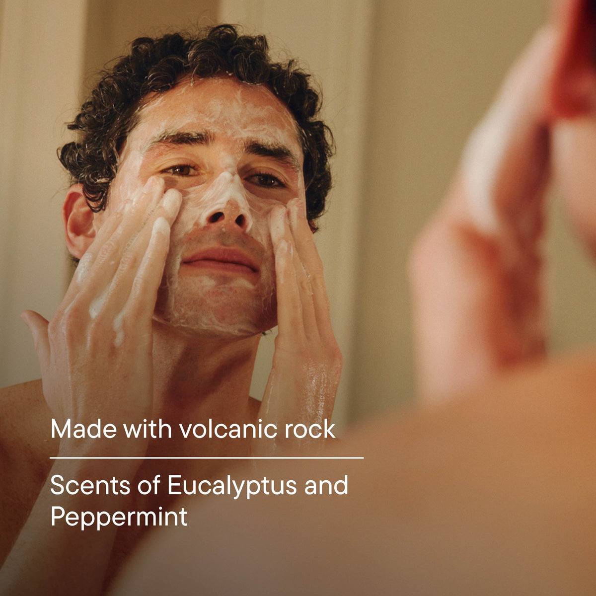 Man applying a facial mask with text about volcanic rock and eucalyptus peppermint scent.