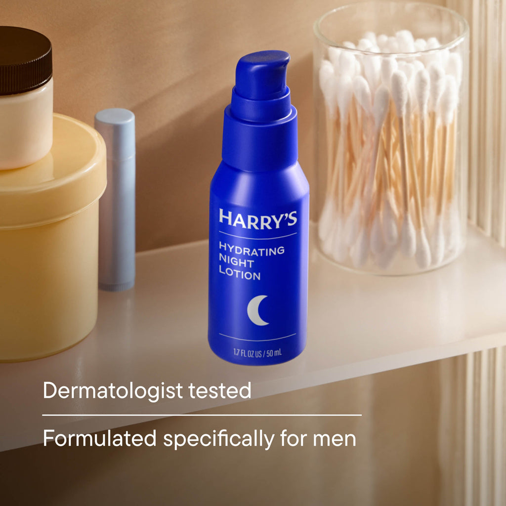 Blue bottle of 'Harry's Hydrating Night Lotion' on a shelf with other skincare products.