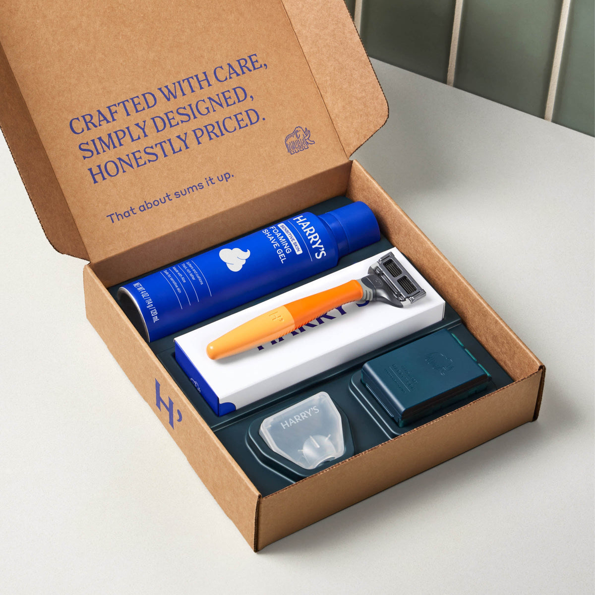 Open cardboard box containing Harry's grooming products on a light surface.