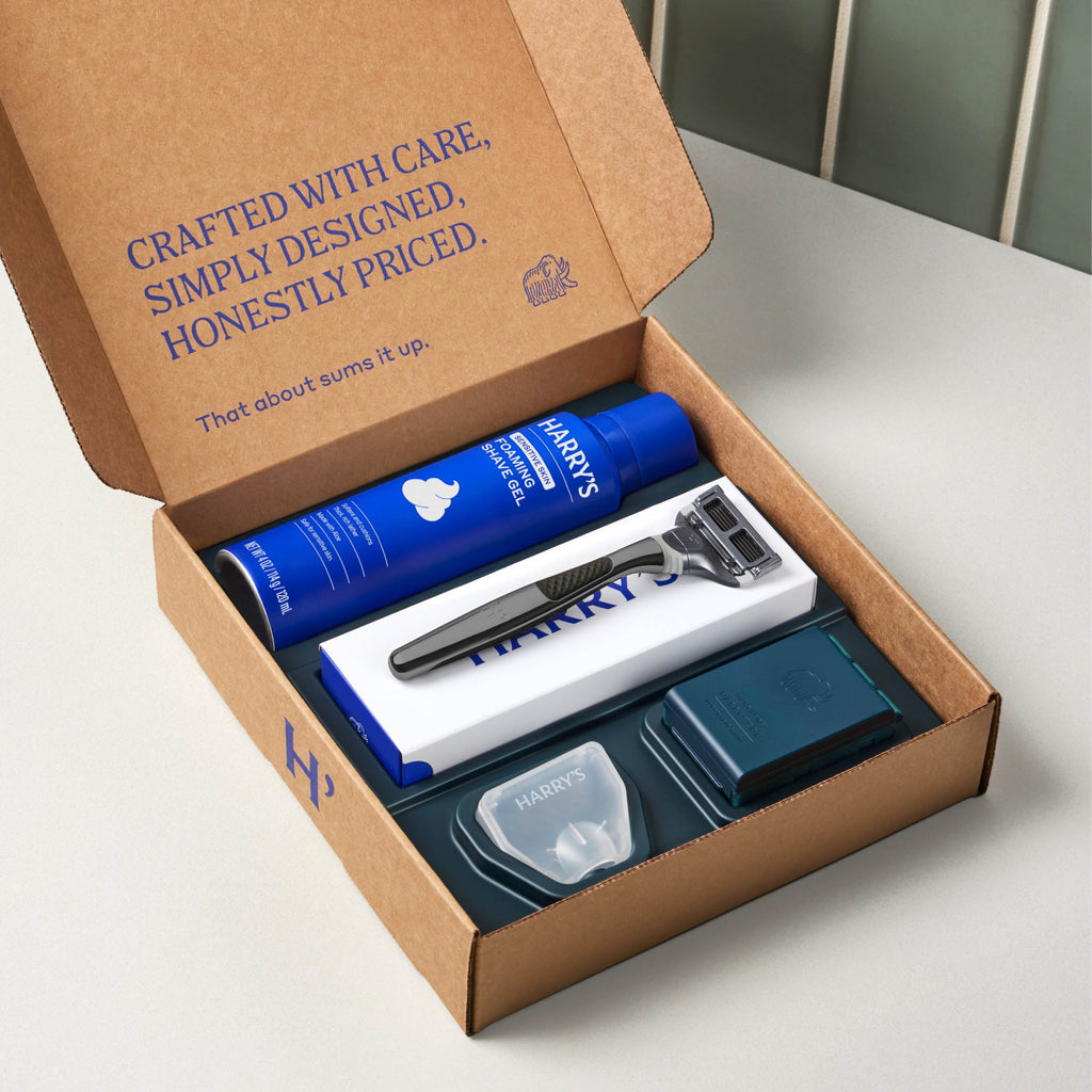 Open cardboard box containing Harry's grooming products on a white surface.