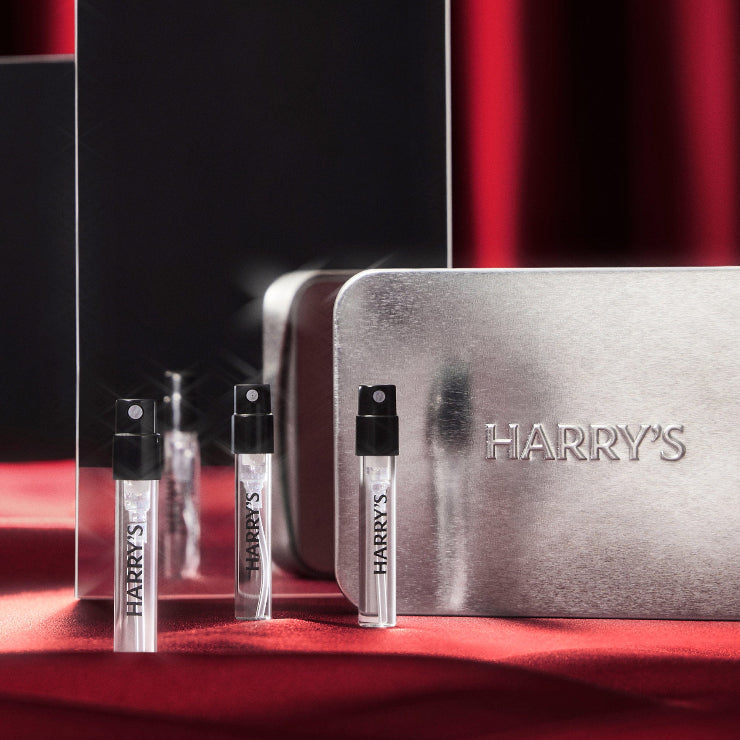 Harry's grooming products including a metallic case and small bottles on a red background