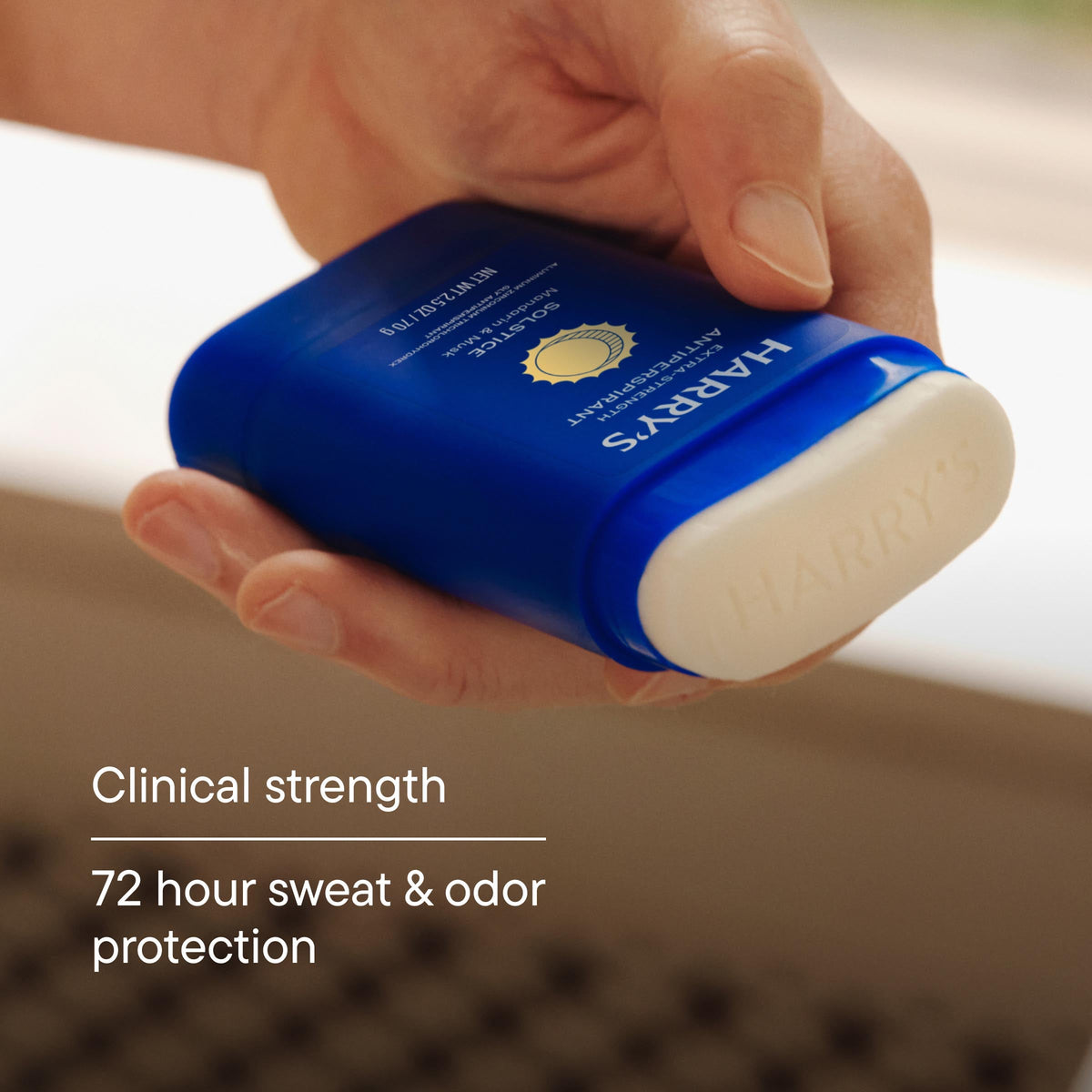 Hand holding a blue and white container of Harpers deodorant with text about clinical strength and protection.