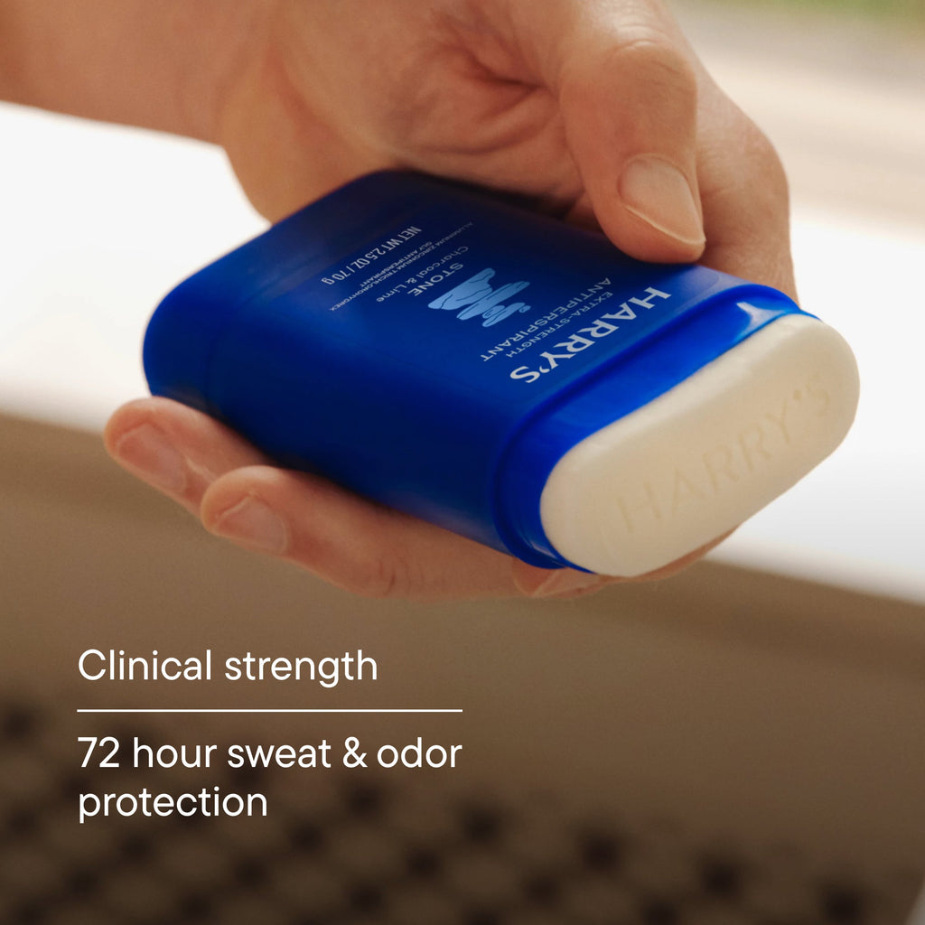 Hand holding a blue deodorant stick with text about clinical strength and protection.