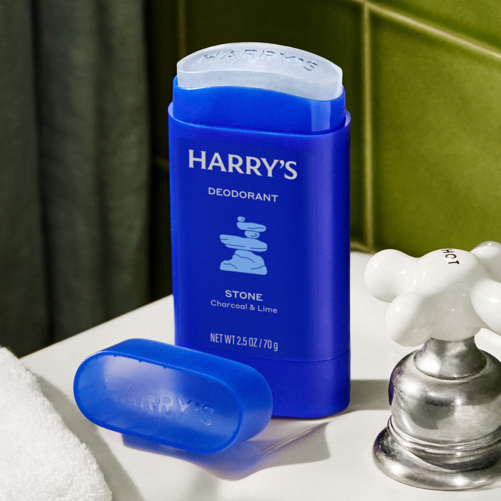 Blue deodorant stick with 'Harry's' branding on a bathroom counter.