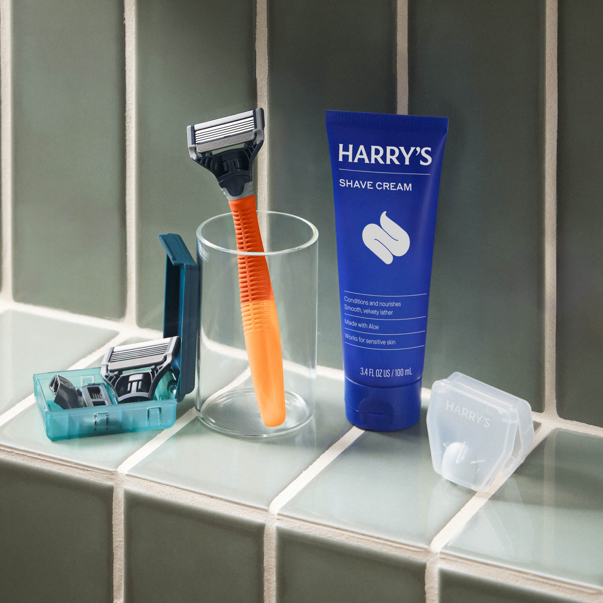 Shaving kit with razor, cream, and accessories on a bathroom counter.