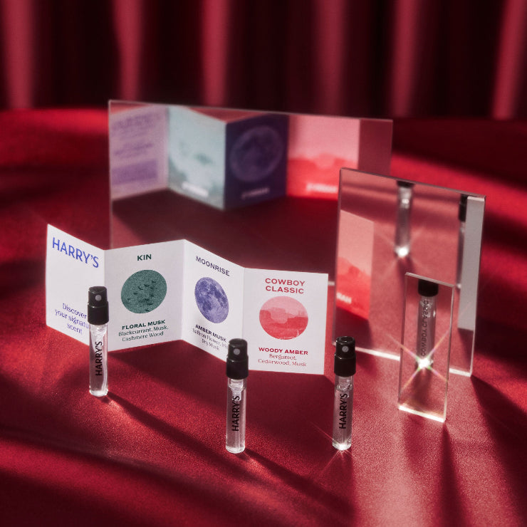 Collection of perfume bottles and packaging on a red fabric background