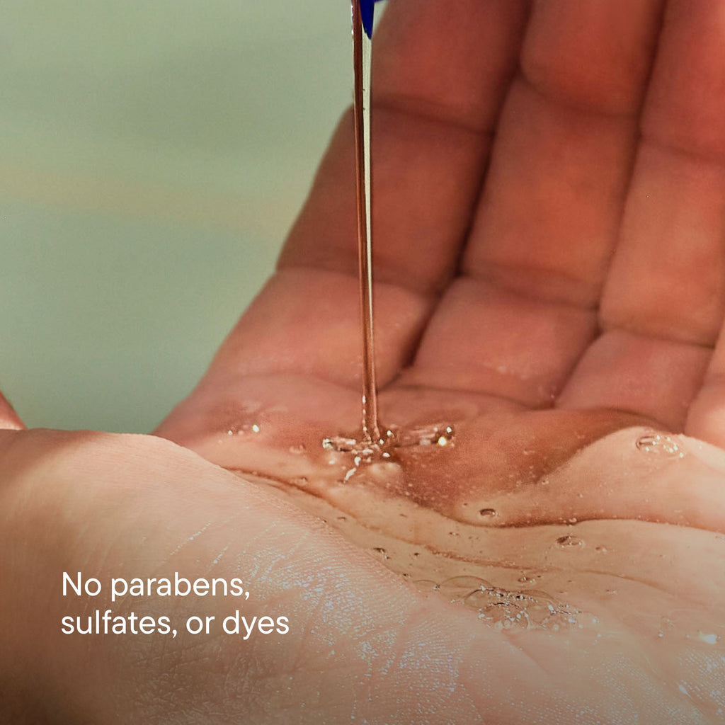 Hand holding a dropper with a clear liquid, labeled 'No parabens, sulfates, or dyes'.
