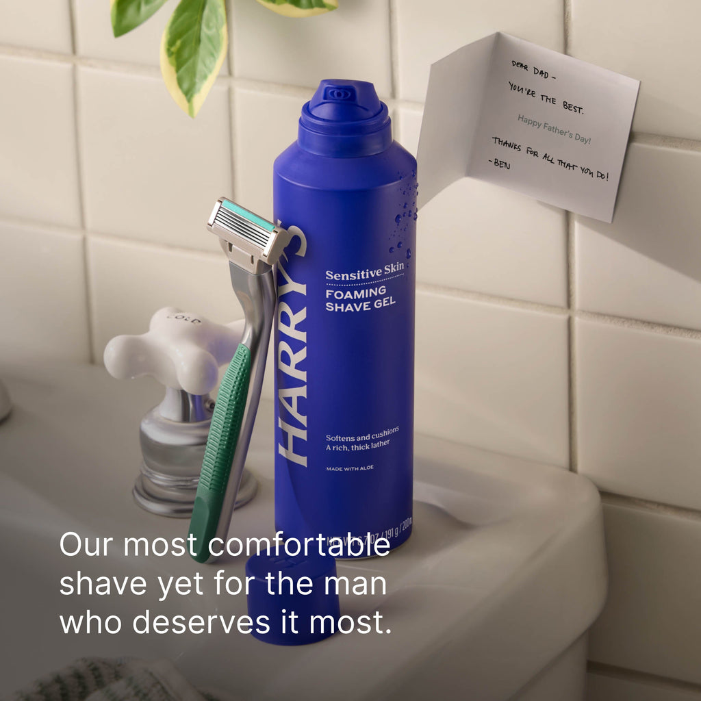 Blue bottle of Harry Foaming Shave Gel on a bathroom counter with a razor and Father's Day card.