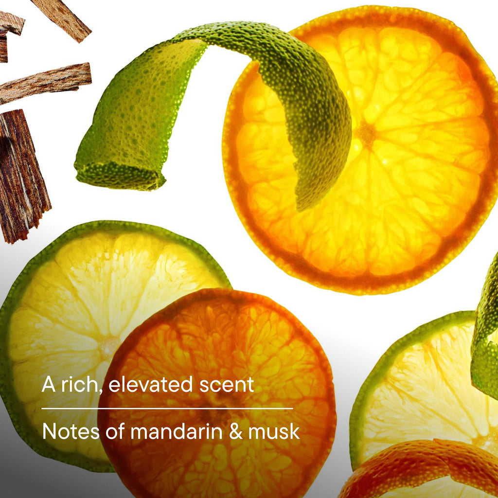 Citrus slices and peel on a white background with text "A rich, elevated scent. Noges of mandarin & musk"