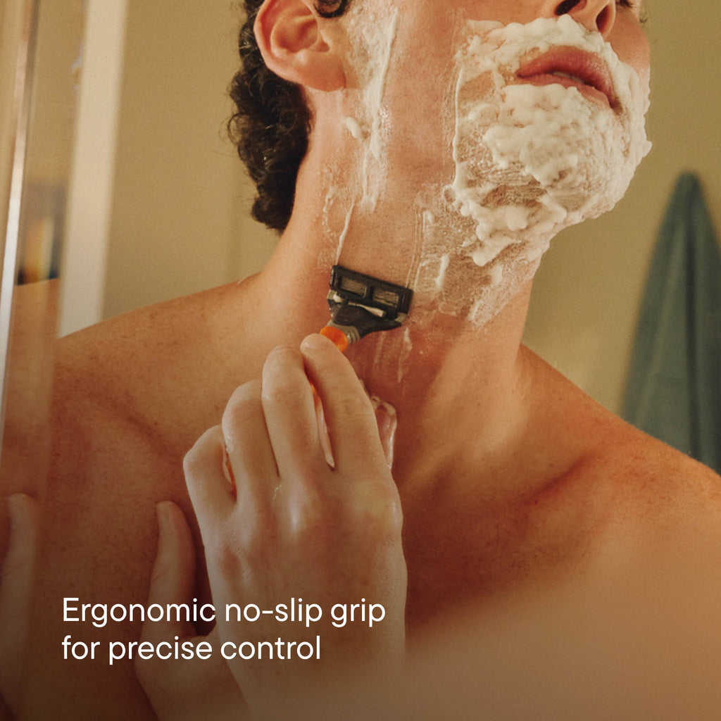 Man shaving with a razor, emphasizing ergonomic design for control.
