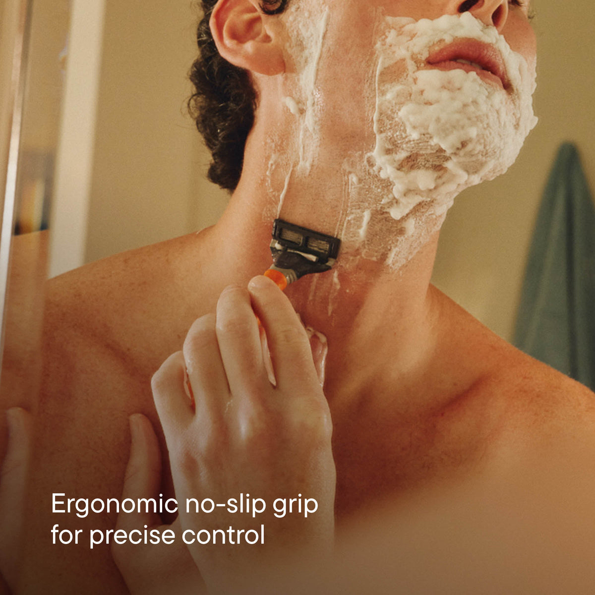 Man shaving with a razor, emphasizing ergonomic design for control.