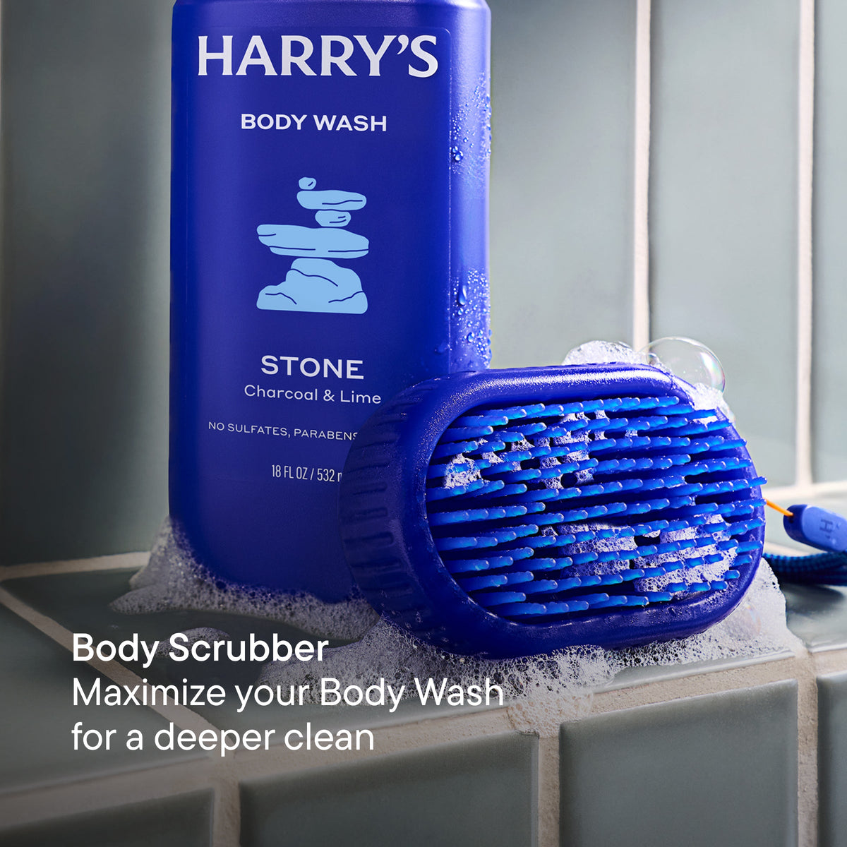 Harry's body wash bottle with scrubber on a tiled surface