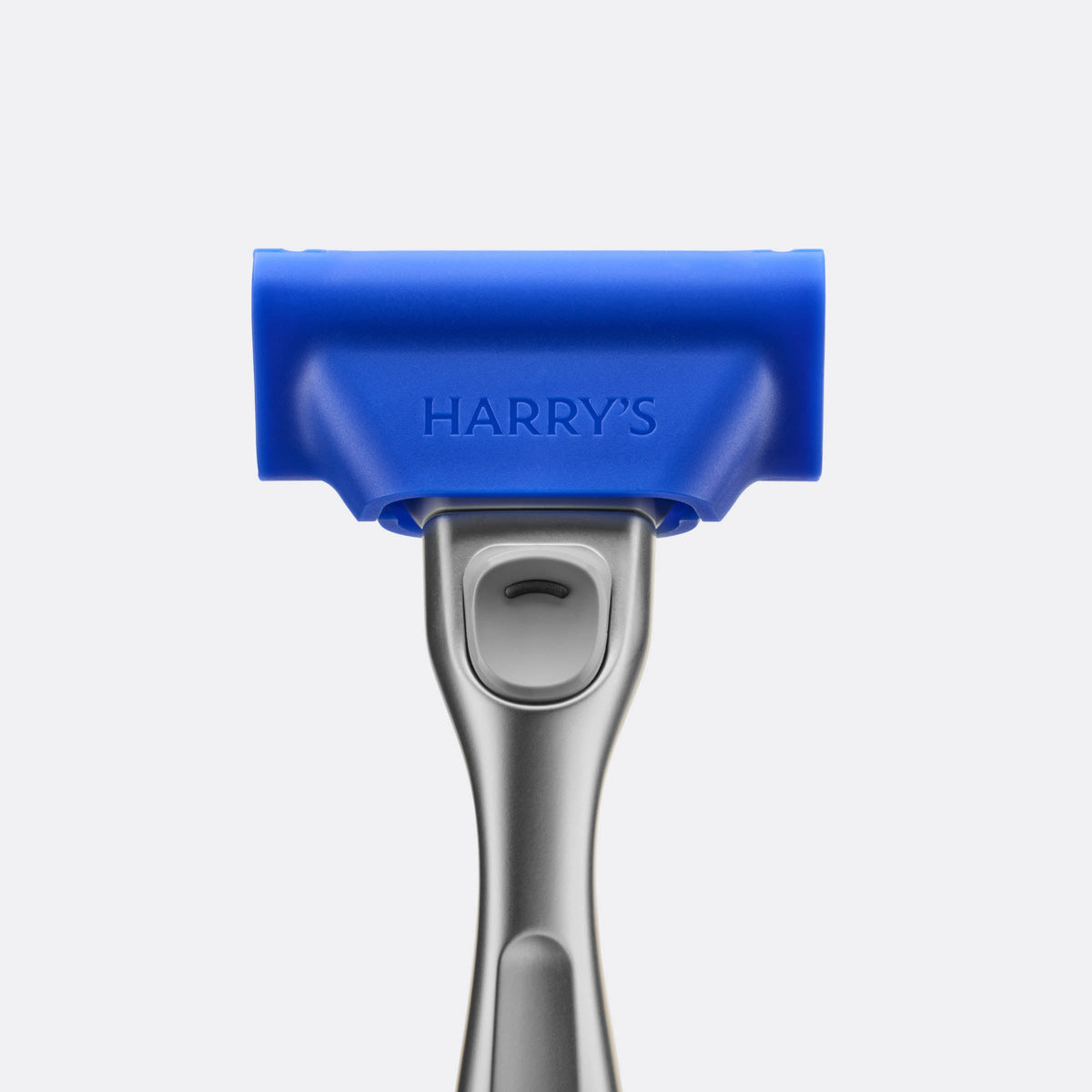 Hair removal tool with blue top and silver handle on a light gray background
