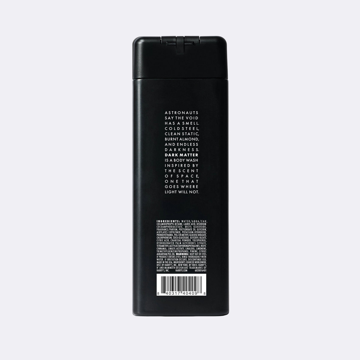 The back of a tall, matte black rectangular bottle with white text and a barcode, photographed against a light gray background.