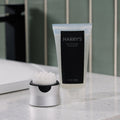 Tube of Harry's gel-to-foam face wash on a bathroom counter