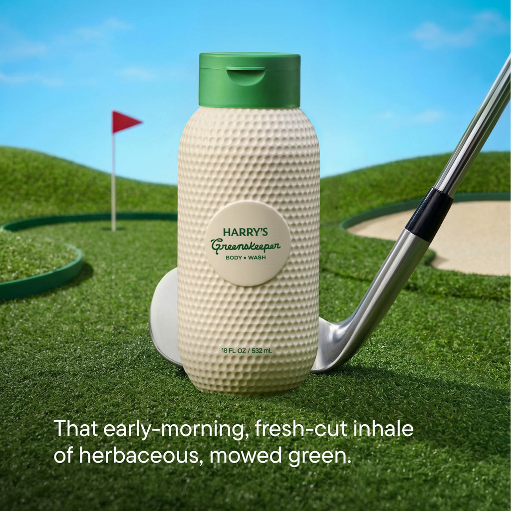 Bottle of Harry's Greenkeeper body wash on a golf course with a golf club and flag in the background.
