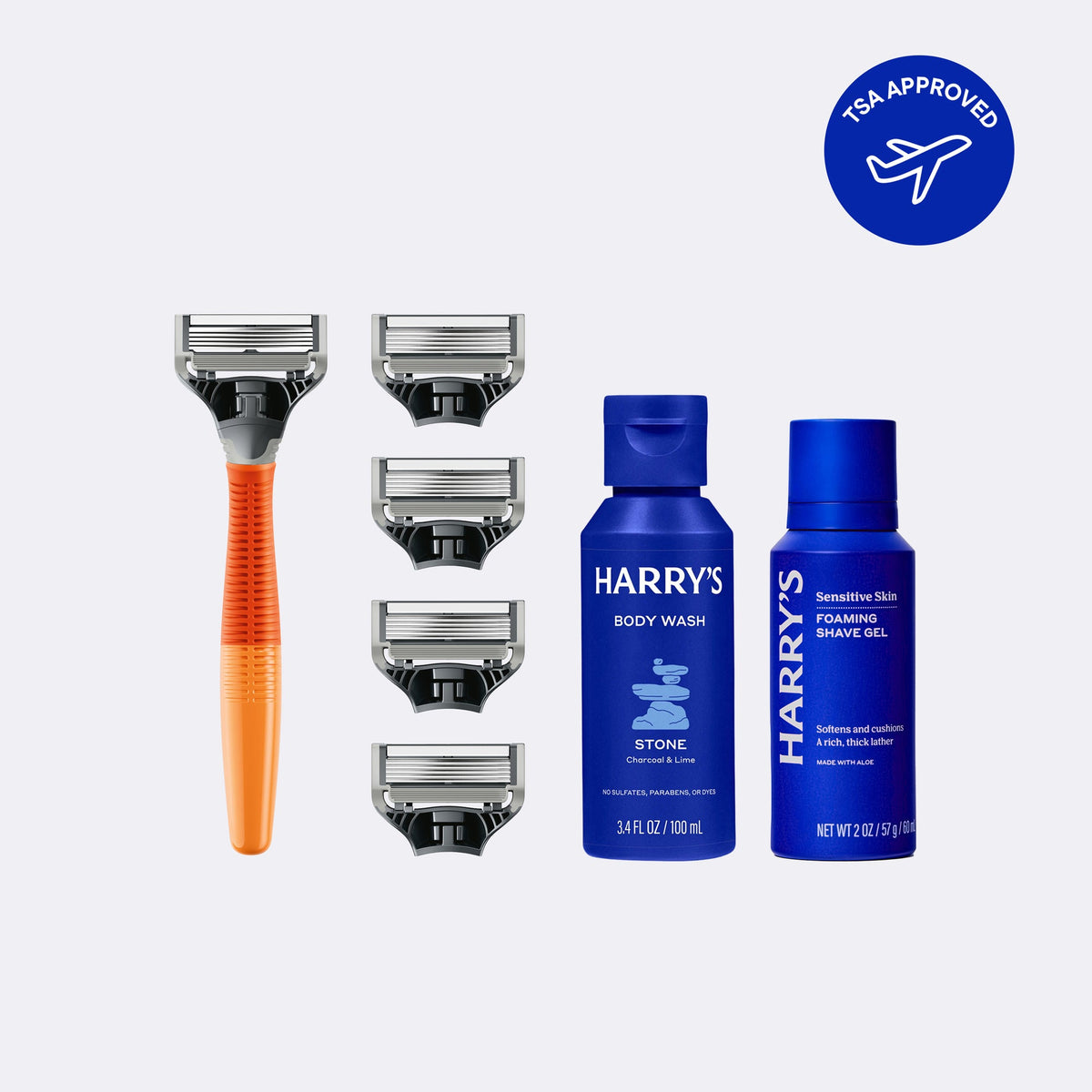 Orange Razor handle, 4 extra Blade Cartrdiges, 1 travel sized blue bottle of body wash, and one travel sized blue bottle of shave gel against a grey background, with a blue stamp with white text saying 'TSA Approved' and a picture of a plane.