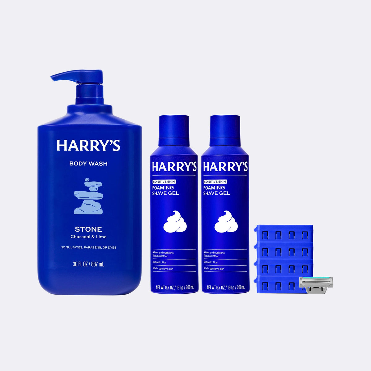 Collection of Harry's grooming products including body wash, foam gel, and razors on a light gray background.