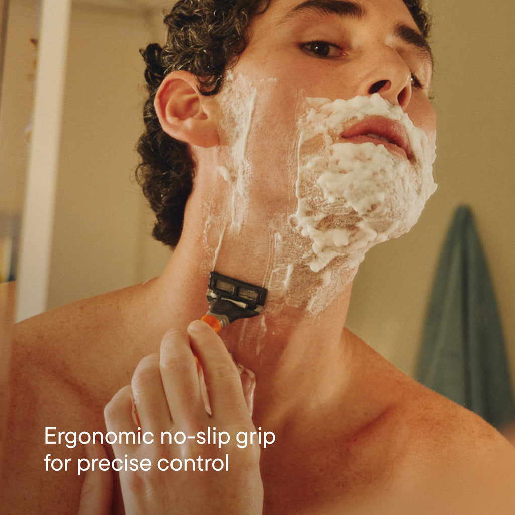 Person shaving their chin and neck with the Ember Truman razor.