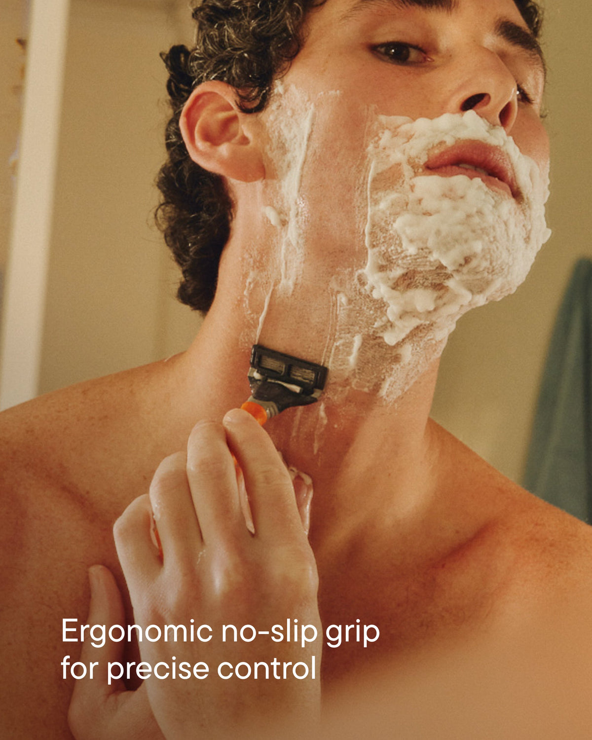 Man with shave gel on his face using the razor to shave his neck.