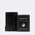 A black anti-shine stick shown with its cap removed, revealing a white applicator top, next to its black packaging container labeled 'HARRY'S Anti-Shine Stick'.