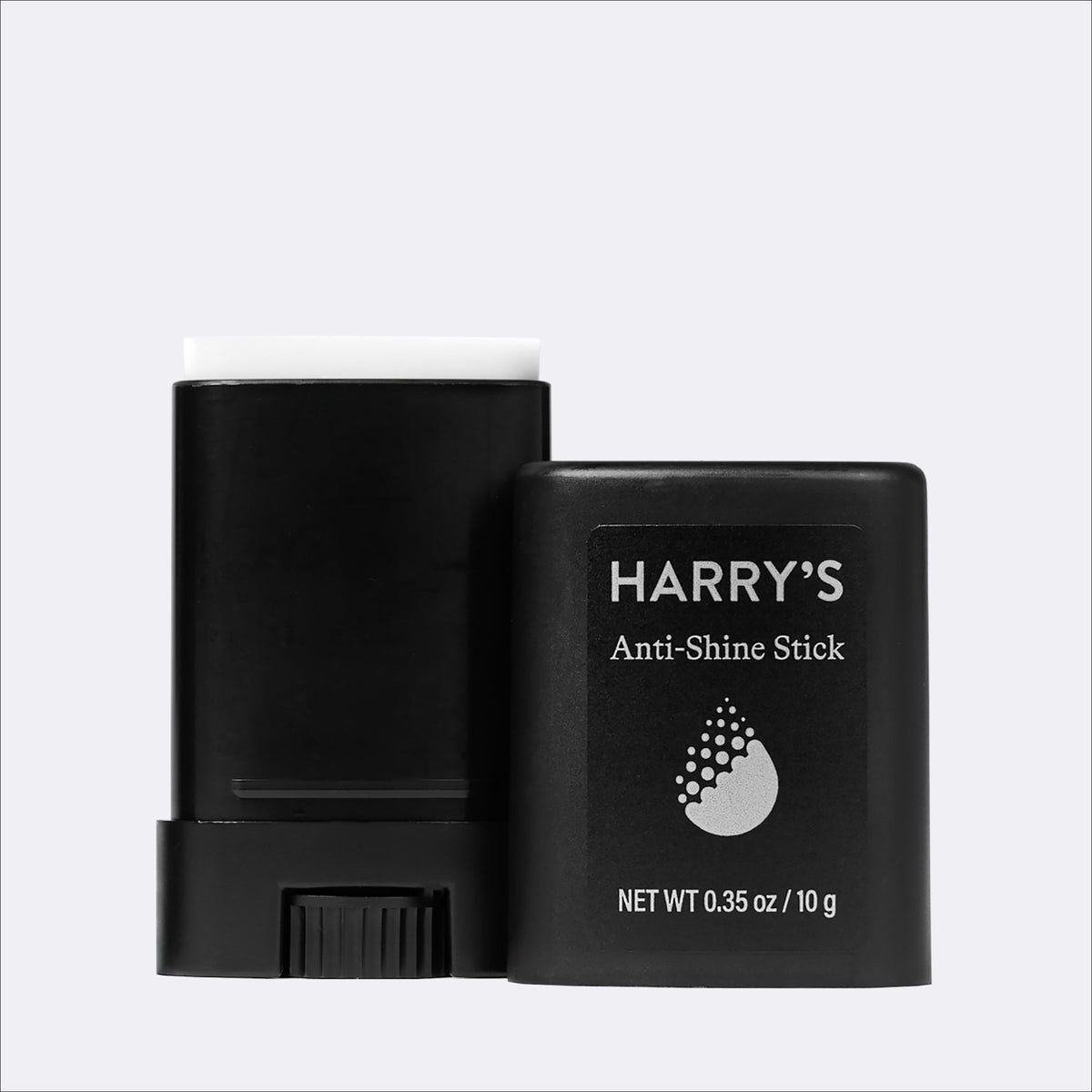 A black anti-shine stick shown with its cap removed, revealing a white applicator top, next to its black packaging container labeled 'HARRY'S Anti-Shine Stick'.
