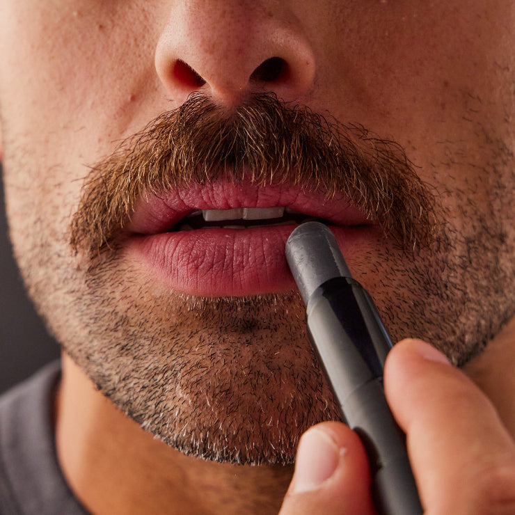 Close-up of a person applying lip balm.