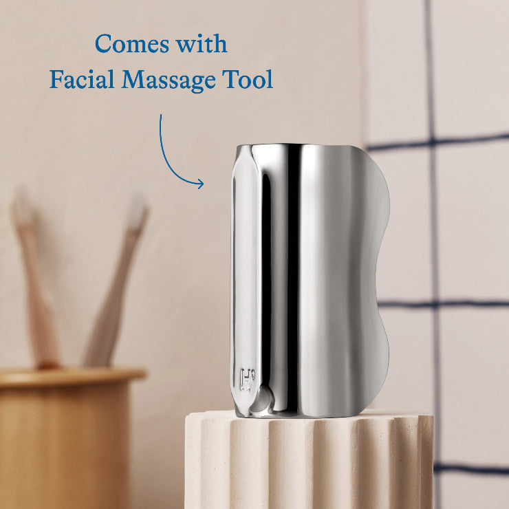 Metallic facial massage tool on a stand with a blurred background