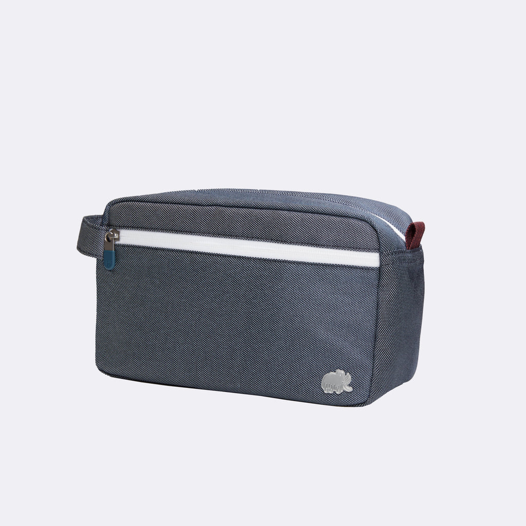 Blue toiletry bag with a white stripe on a light gray background