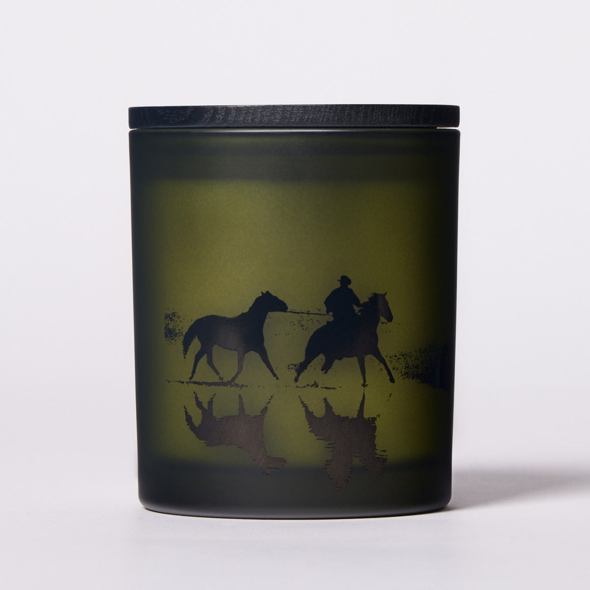 Candle with horse design on a black lid and base.