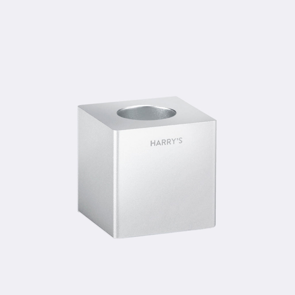 Harry's razor stand, a block of steel with a hole in the top to hold razors.