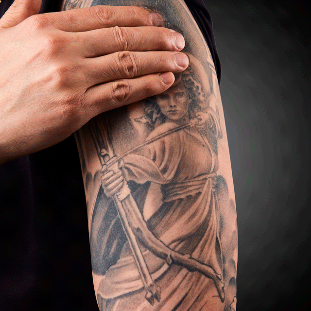 Gif of person applying the frost to a large tattoo on their upper arm.