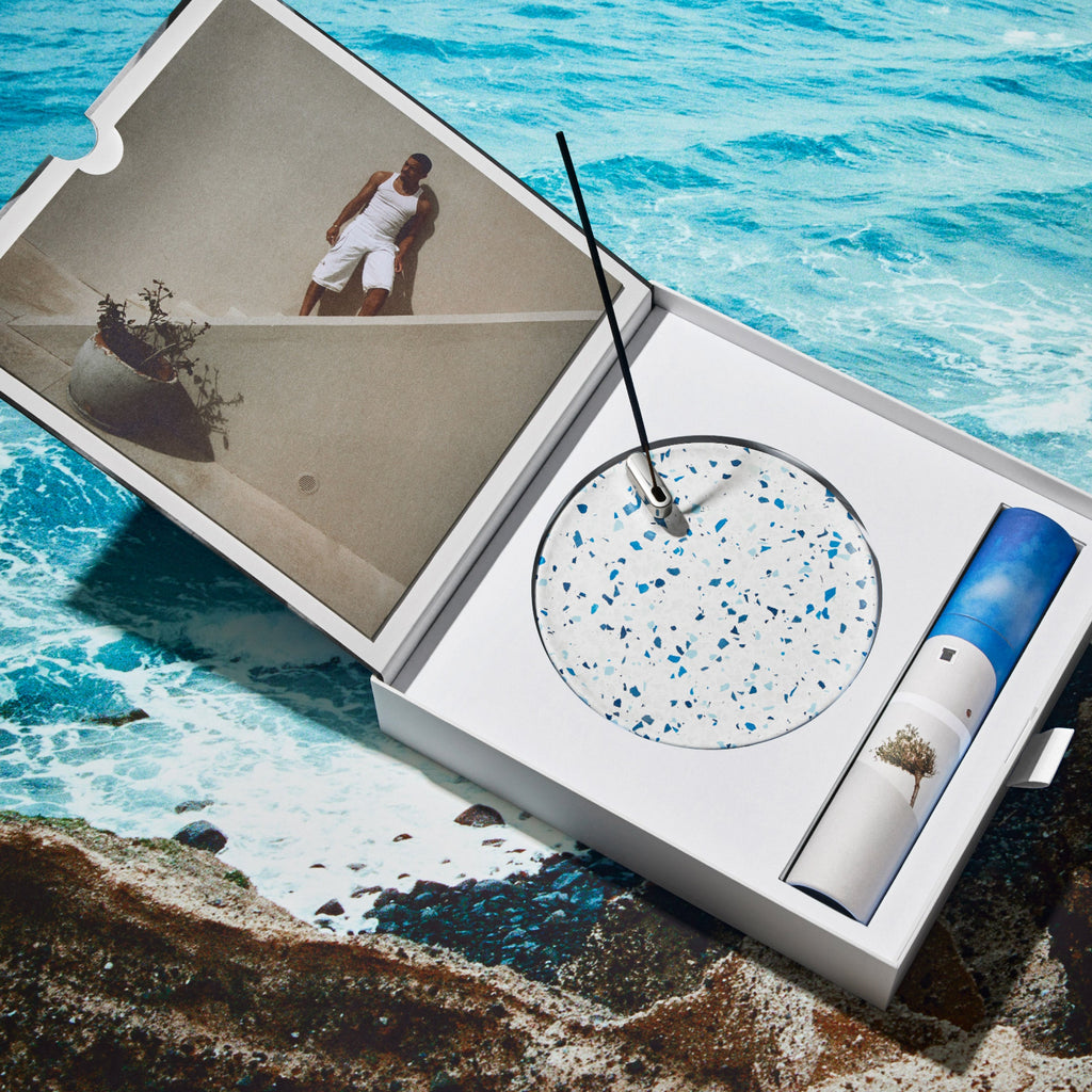 Incense set in its packaging over a photograph of the Mediterranean sea.