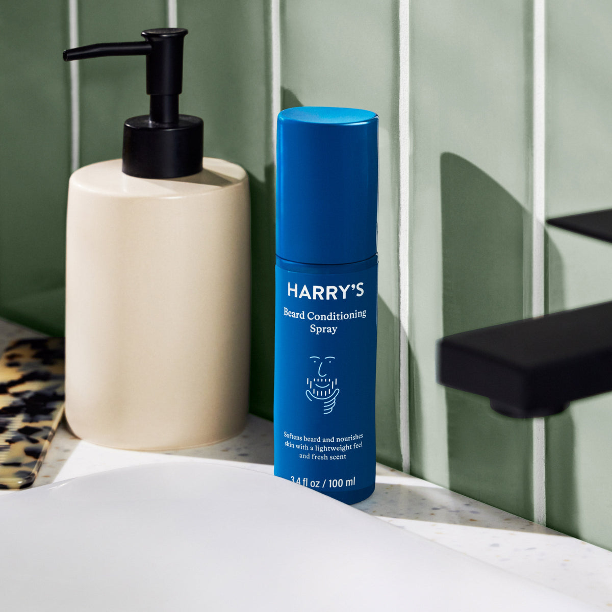 Blue bottle of 'Harry's' beard conditioning spray on a bathroom counter.