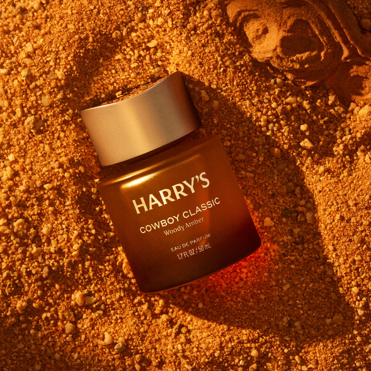 Harry's Cowboy Classic Woody Amber eau de parfum bottle on a textured orange surface